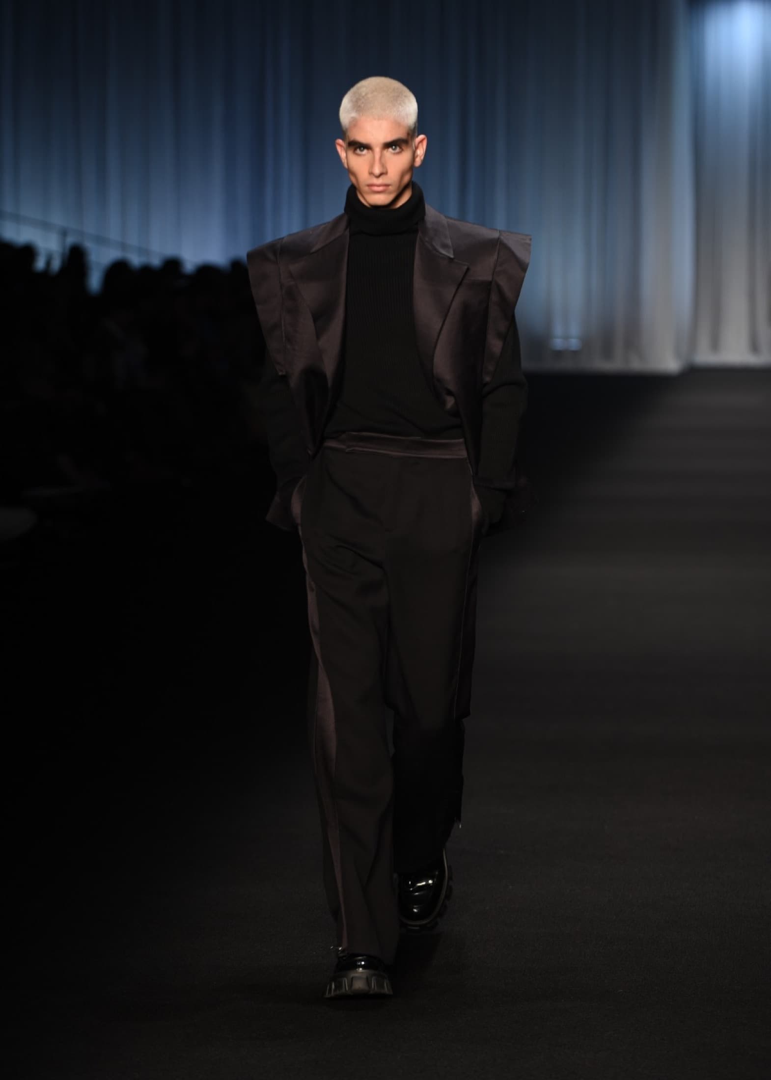 Model in an oversized black shirt-jacket and long black skirt, profile view — Bogotá Fashion Week